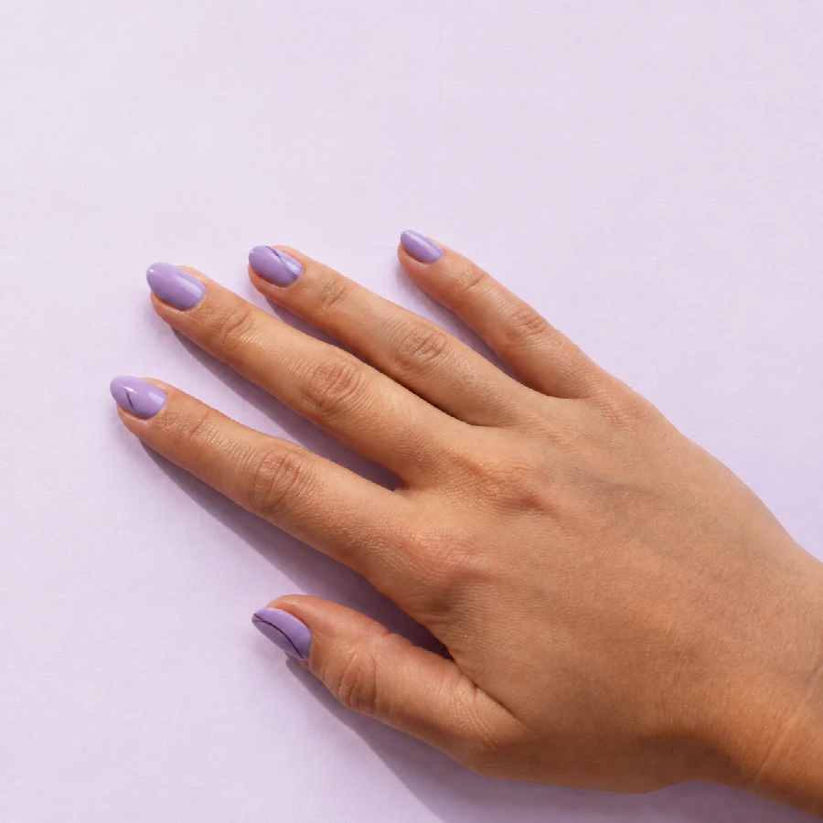 Referencia editorial de uñas ovaladas esmaltadas en tonos lila.